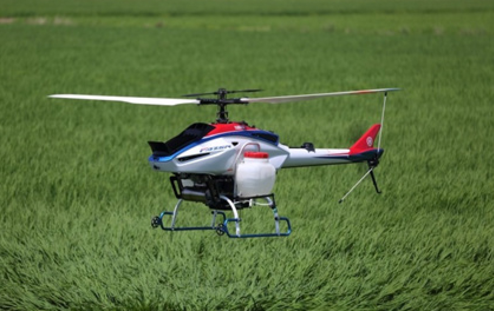 무인헬리콥터(회전익)가 들판 위를 비행하는 사진